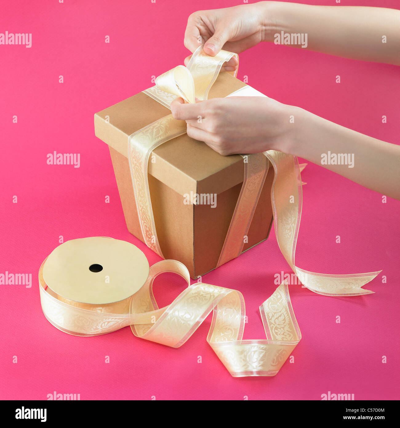 hands tie a package with ribbon Stock Photo Alamy