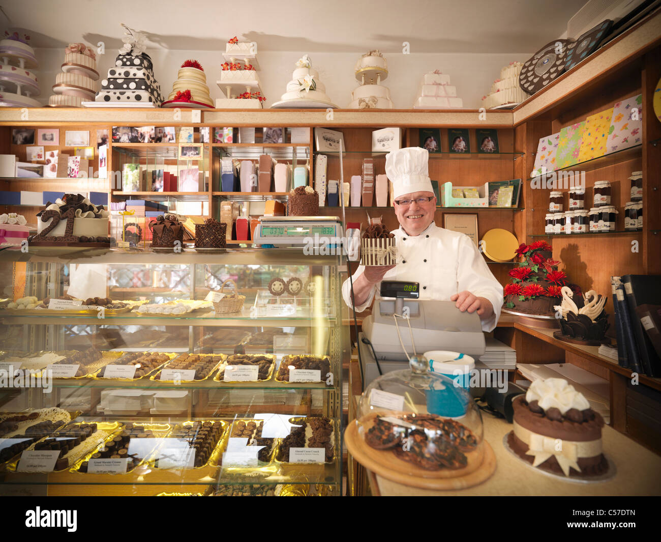 Baker at register in cake shop Stock Photo