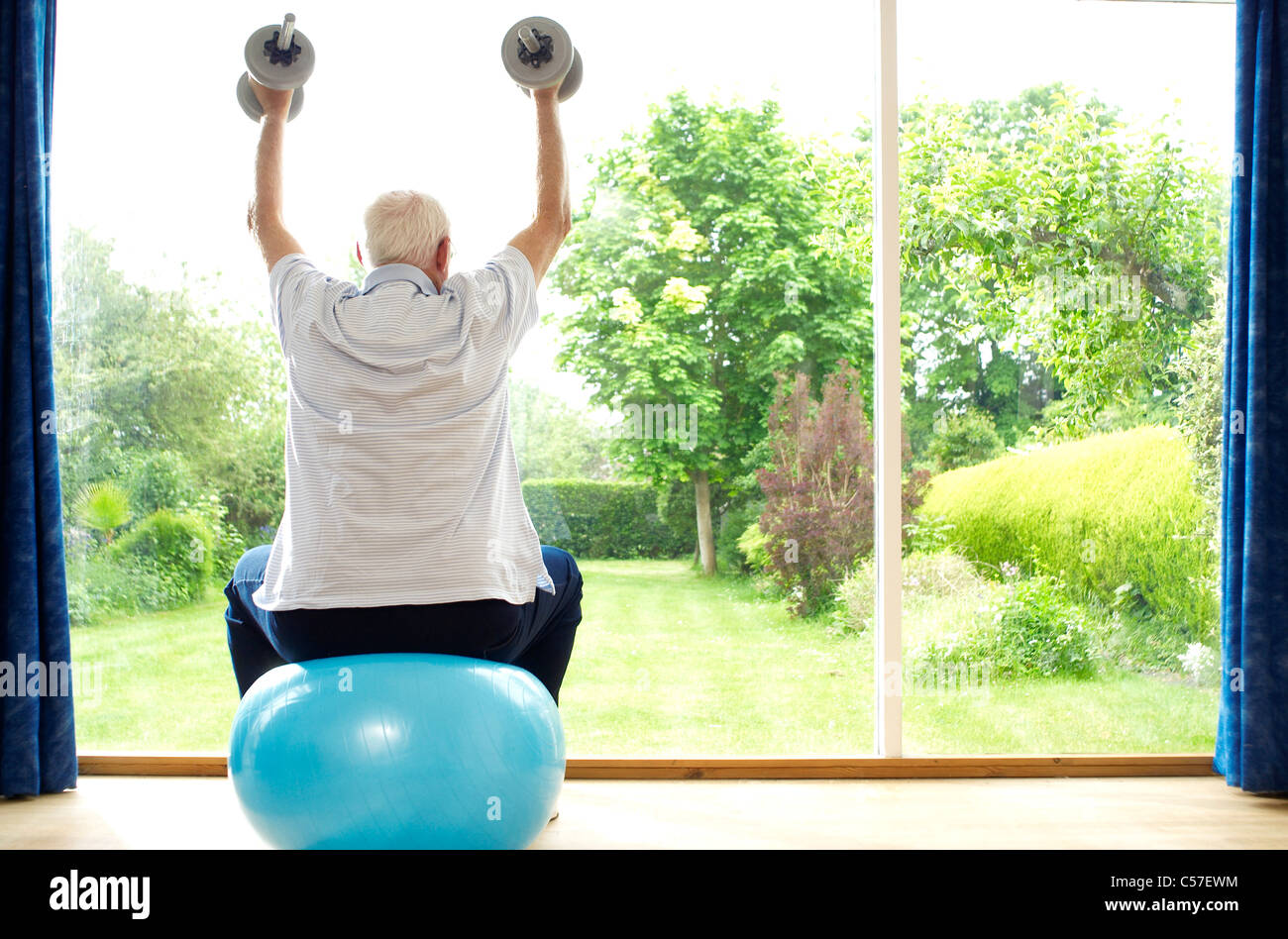 Man lifting weights on exercise ball Stock Photo Alamy