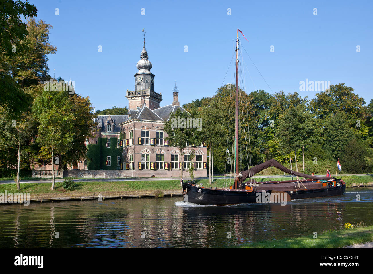 The Netherlands, Breukelen, Nyenrode, Nijenrode Castle along the river Vecht. Nyenrode Business University. Traditional sailing boat. Stock Photo