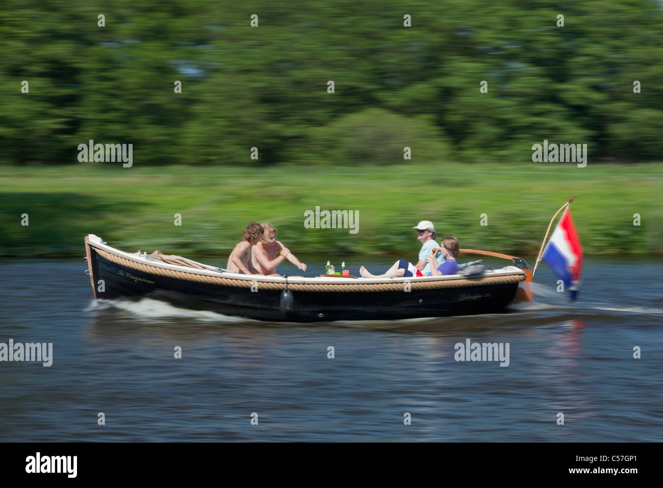 The Netherlands, Vreeland, People in pleasure boat on river called Vecht Stock Photo