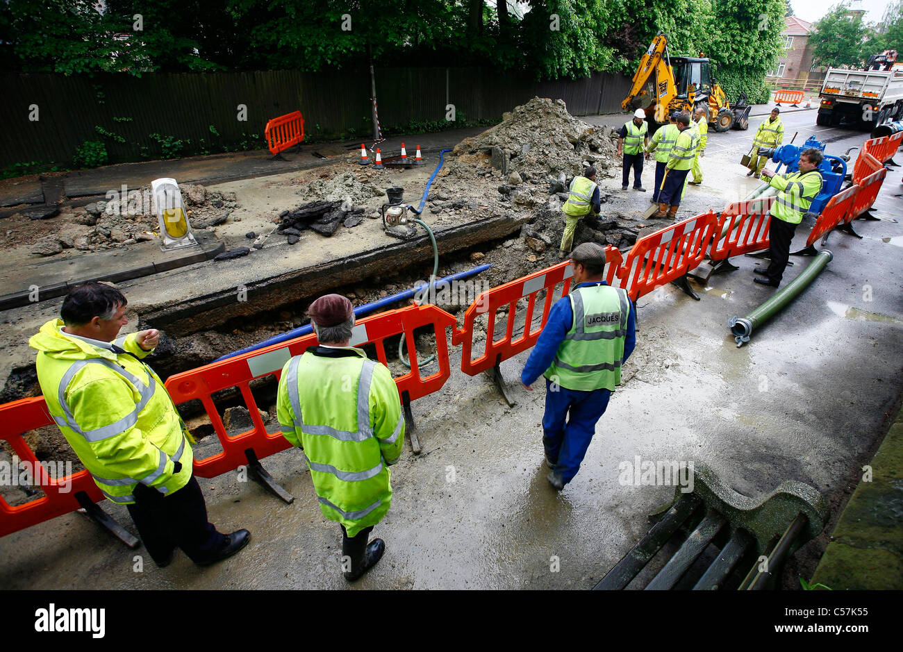 Workmen repair a burst water main in the road. Picture by James Boardman. Stock Photo
