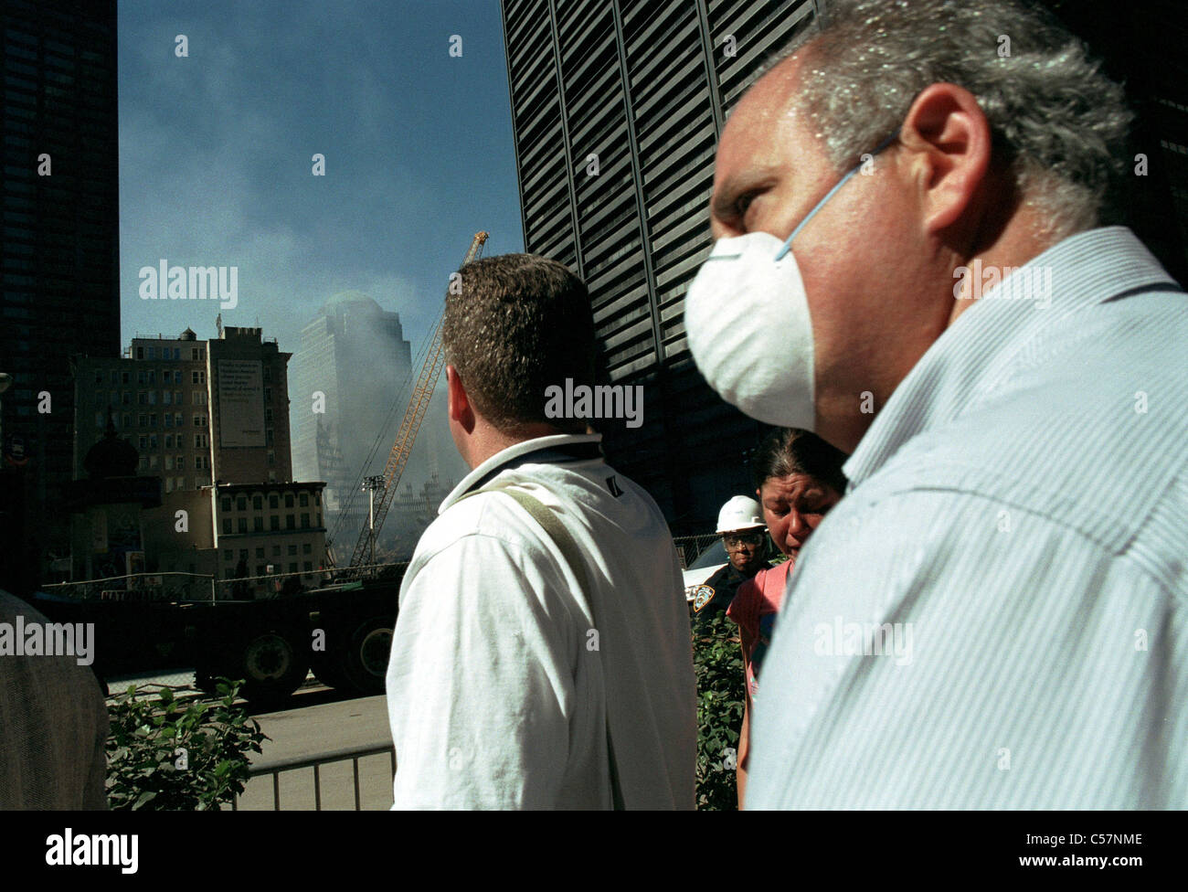 People walk down Broadway past the site of the world Trade Center terrorist attack wearing masks Stock Photo