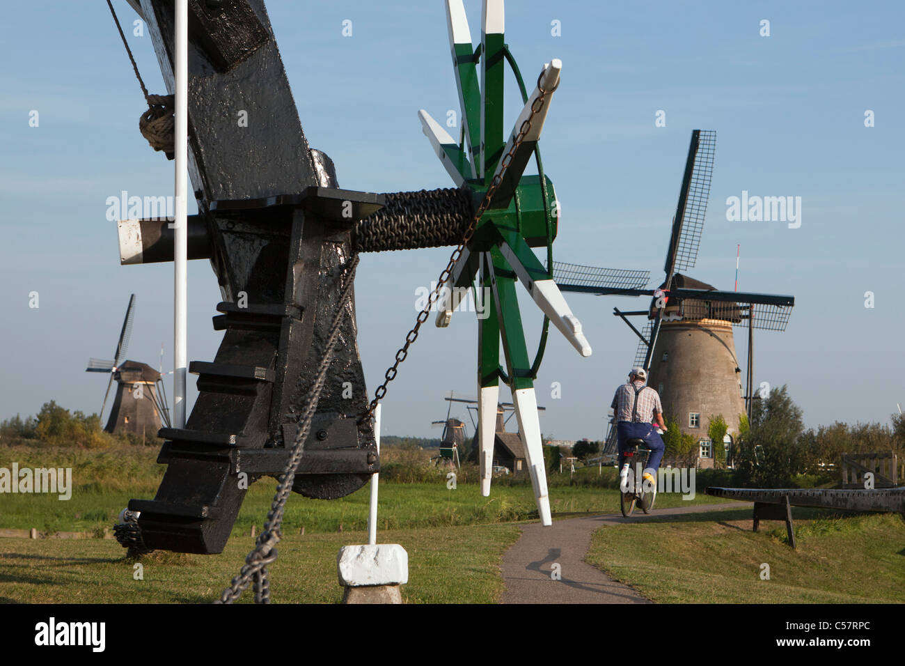 The Netherlands, Kinderdijk, Windmills, Unesco World Heritage Site. Miller with wooden shoes on bicycle Stock Photo