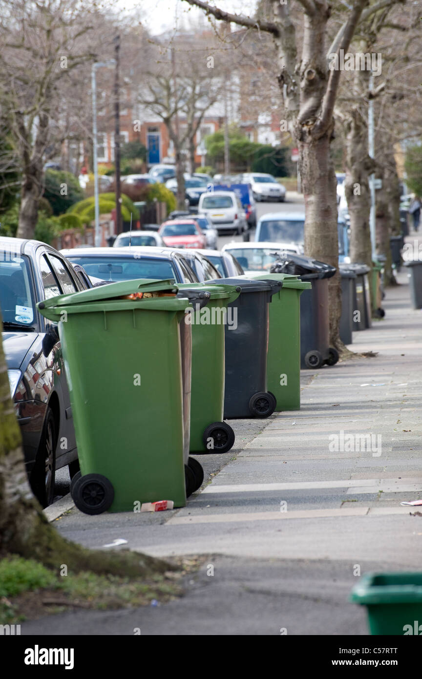 Wheelie bins containing household waste waiting for collection outside