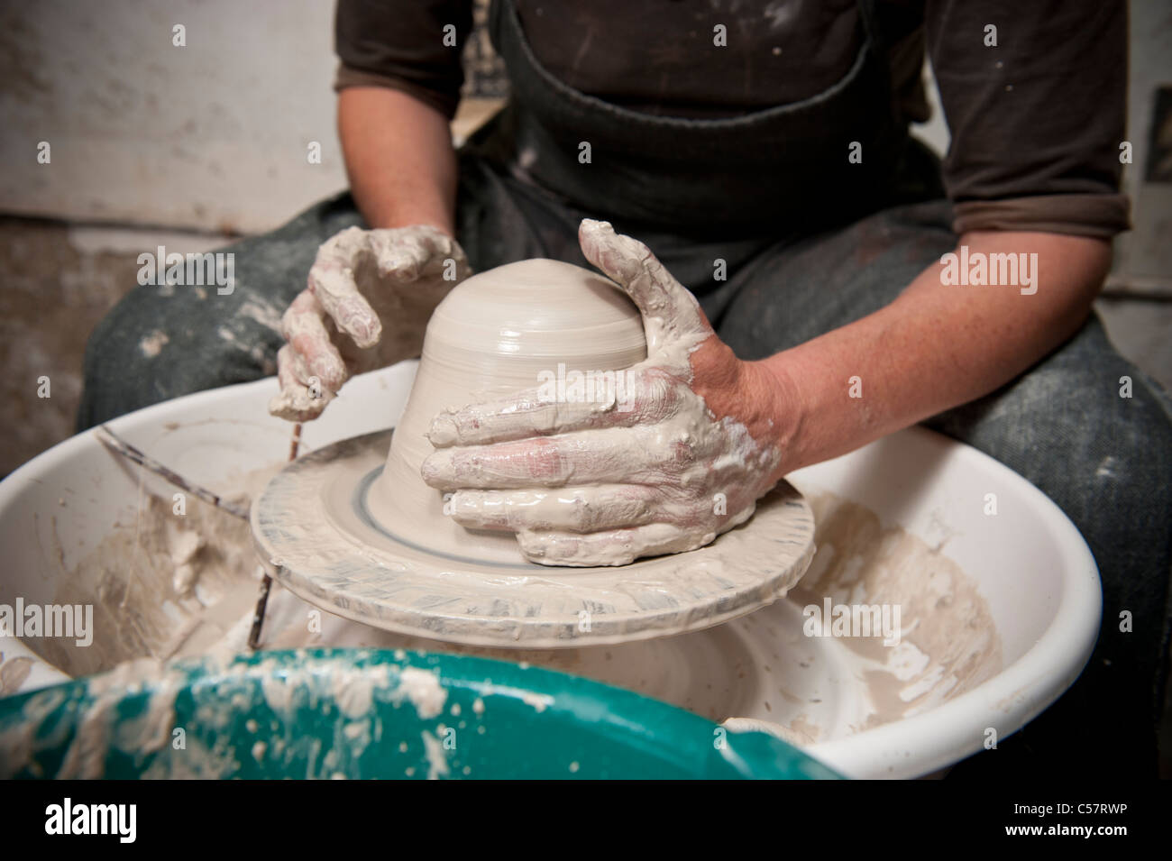 Female ceramicist using a Potter's wheel to work on a ceramic piece in her Barcelona