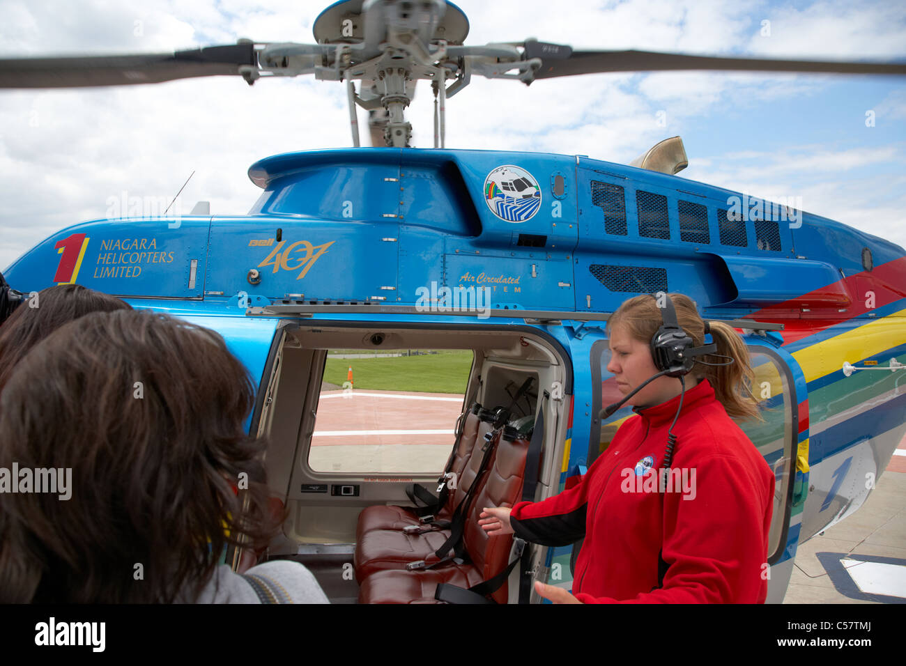 tourists approaching helicopter rear seats for flight over niagara falls ontario canada Stock Photo