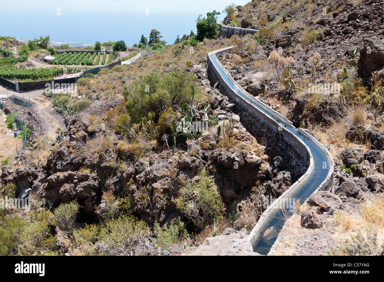 An open water channel carring water for crop irrigation in the Guia de Isora area of Tenerife, Canary Islands, Spain Stock Photo