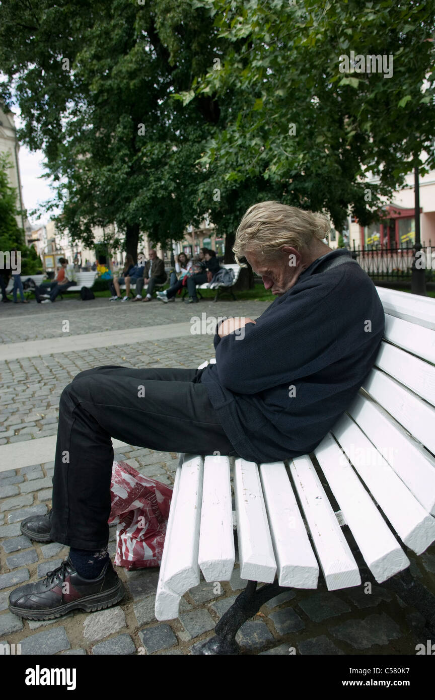 A slovakian homeless alcoholic sitting on a park bench
