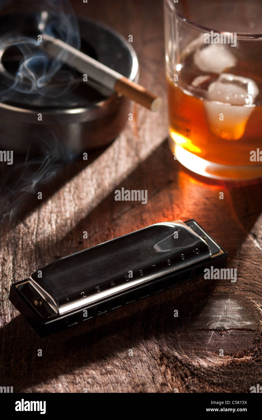 Blues Black Harmonica with a Glass of Whiskey and Smoking Cigarette with Ashtray Stock Photo
