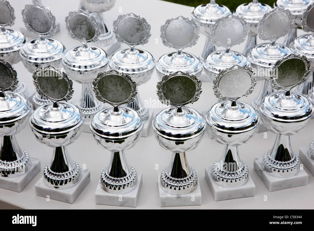 Silver cups waiting for winners of a sports competition. Stock Photo