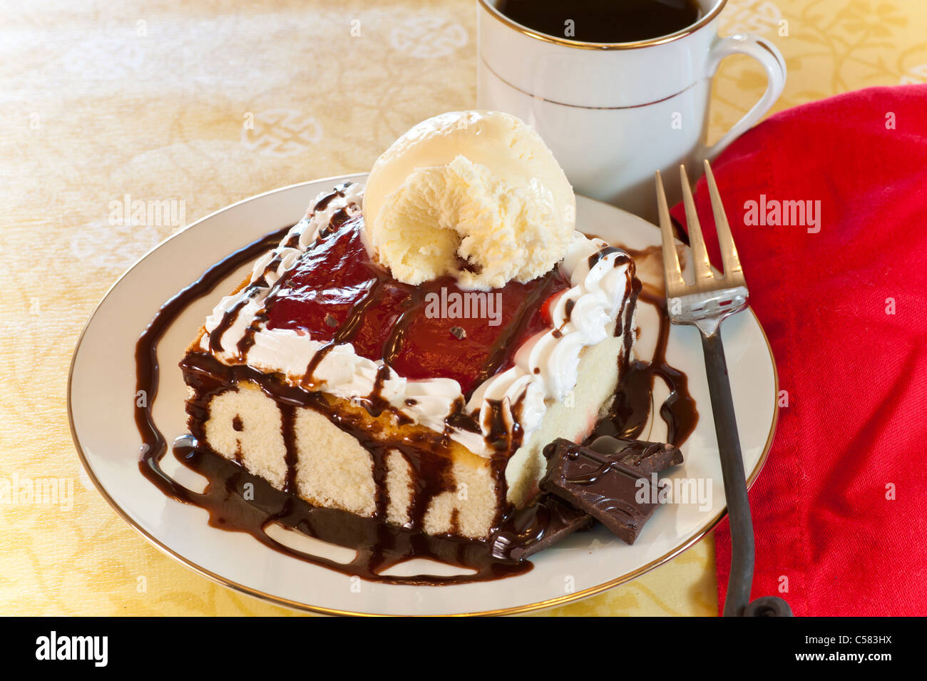 White cake with raspberry chocolate topping plus vanilla ice cream and coffee. Stock Photo