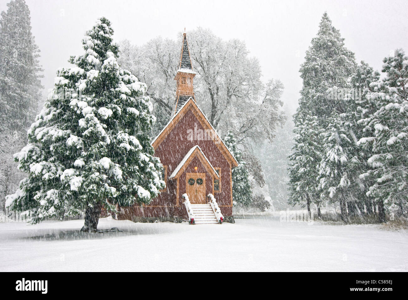 Yosemite Valley Chapel adorned in Christmas decorations during a snow storm - Yosemite National Park, California Stock Photo