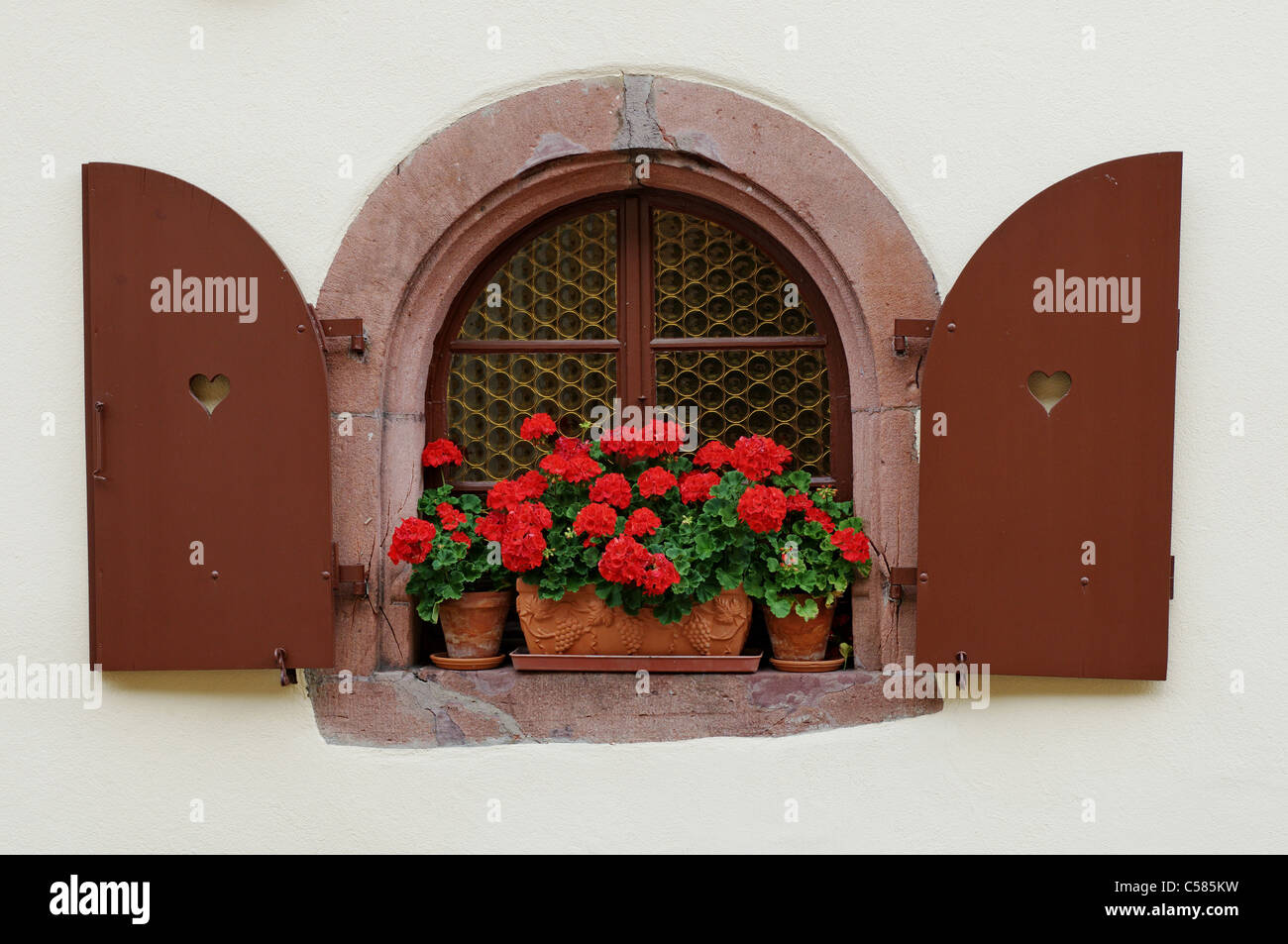Kaysersberg, Alscace, Alsatia, France, window, arched window, flowers, decorated with flowers, geranium, window shutter, still l Stock Photo