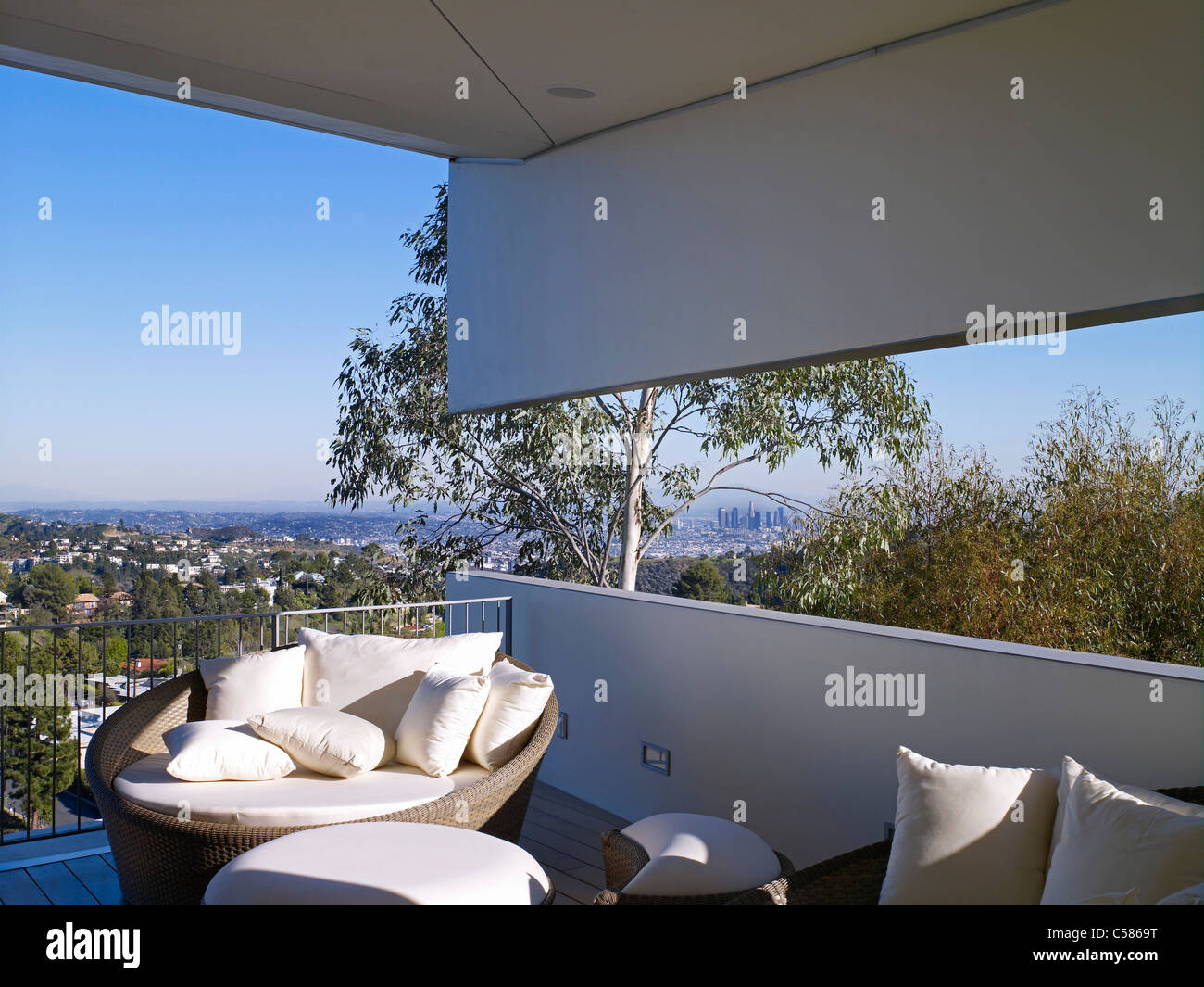 Balcony with views over the plain. Outdoor furnishings with white cushions. Stock Photo