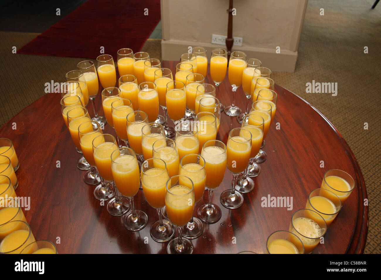 wine glasses filled with orange juice arranged in the shape of a heart Stock Photo