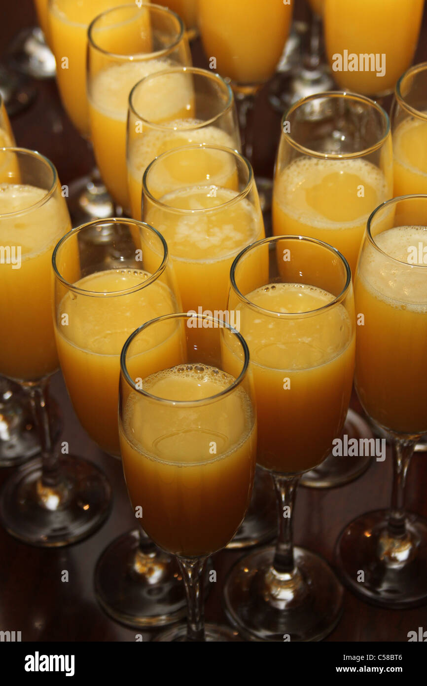 wine glasses filled with orange juice arranged in the shape of a heart Stock Photo