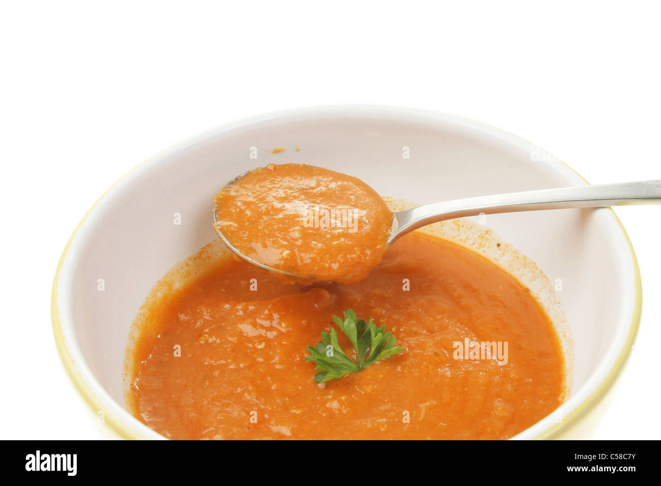 Tomato soup in a spoon and bowl Stock Photo