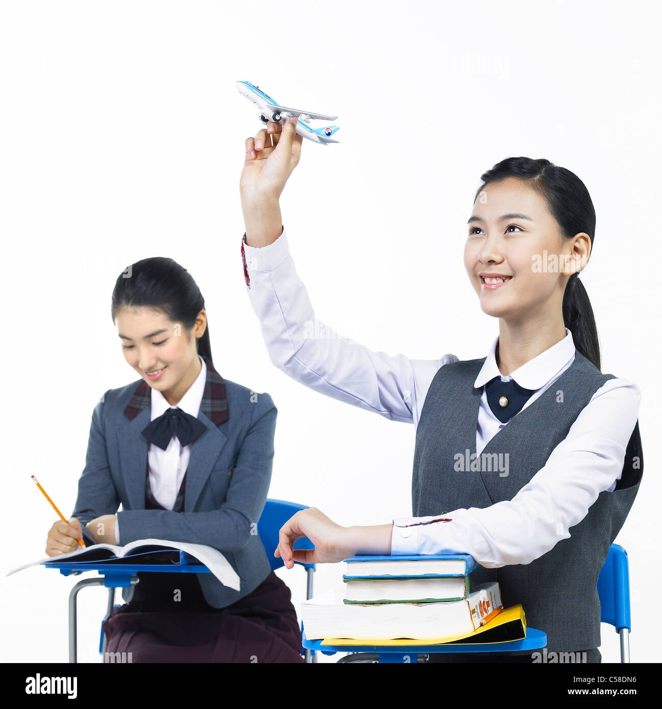 Side view of teens sitting on chair Stock Photo - Alamy