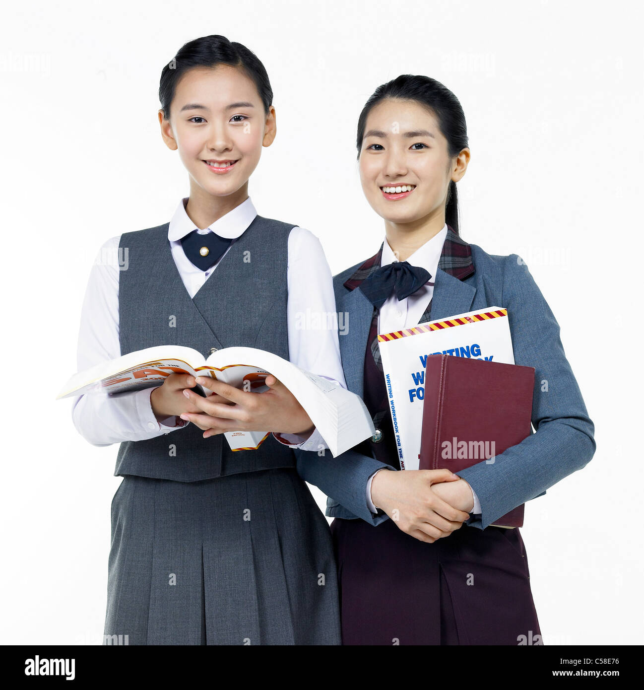 Portrait of teenage girls holding book Stock Photo - Alamy