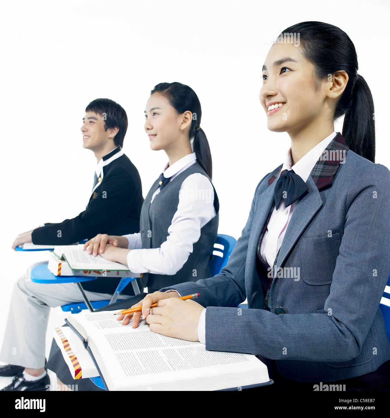 Side view of teens sitting on chair Stock Photo - Alamy
