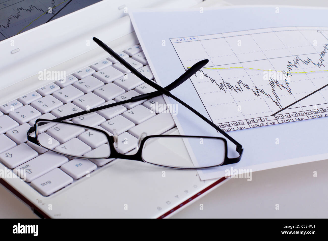 stock chart and glasses on a white netbook Stock Photo