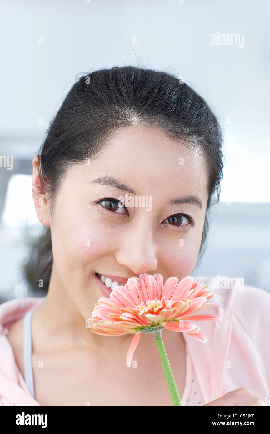 Portrait of young woman holding flower Stock Photo - Alamy