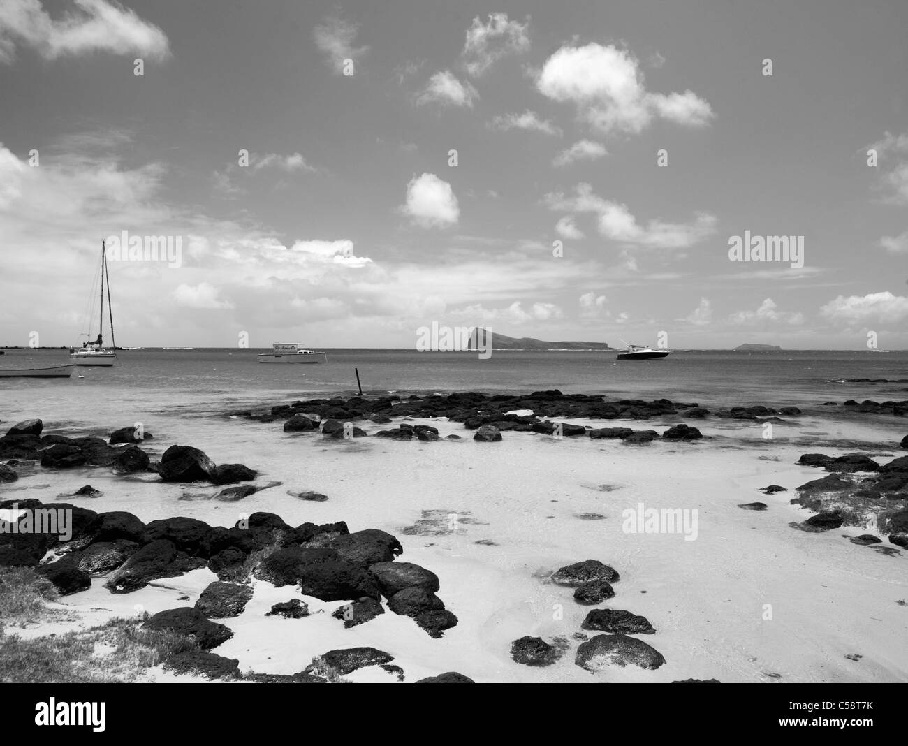 Coin de Mire Island Nature Reserve and Yacht off Cap Malheureux Mauritius and Man in Small Boat Stock Photo