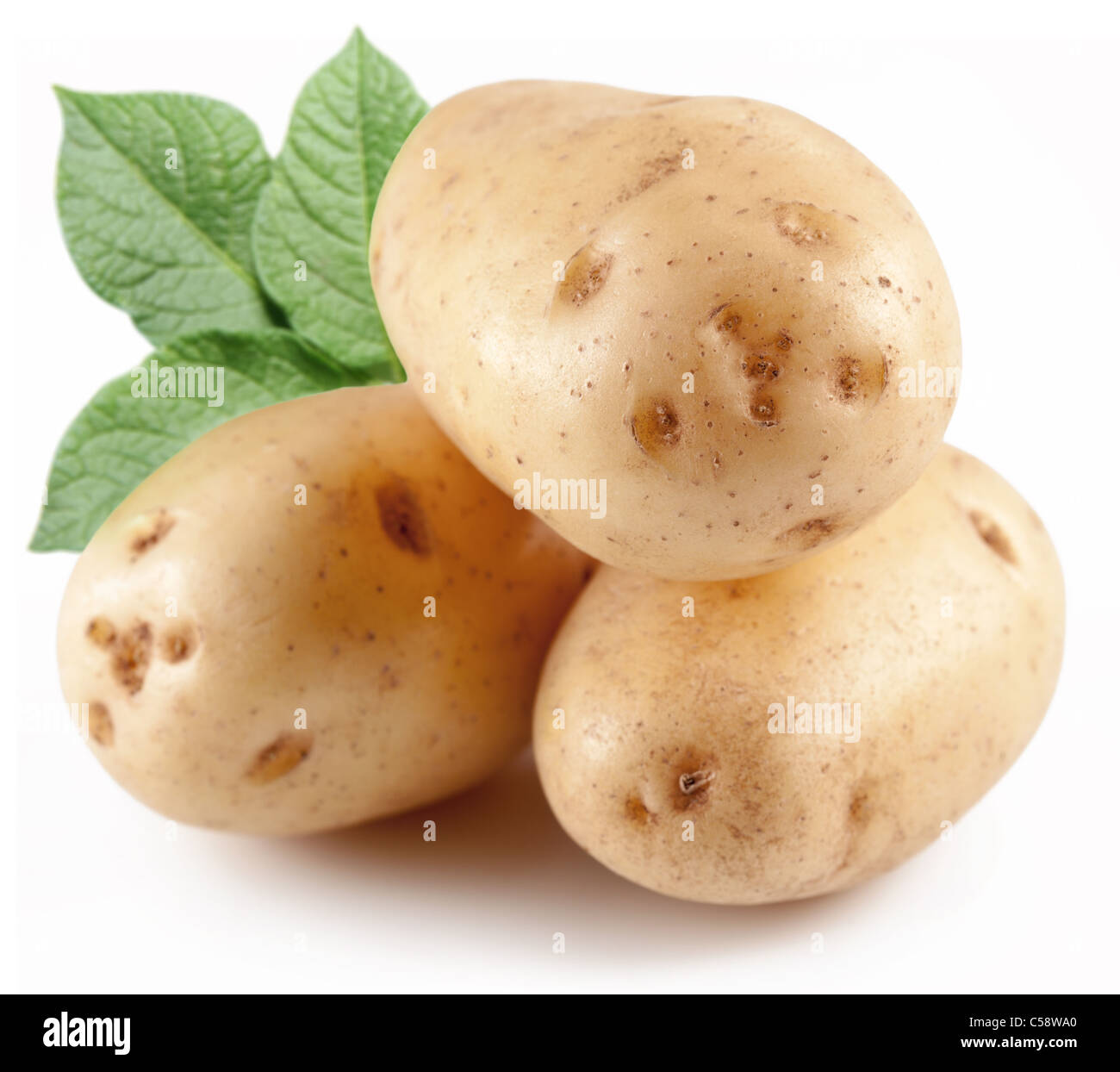 Three potatoes with leaves isolated on a white background Stock Photo
