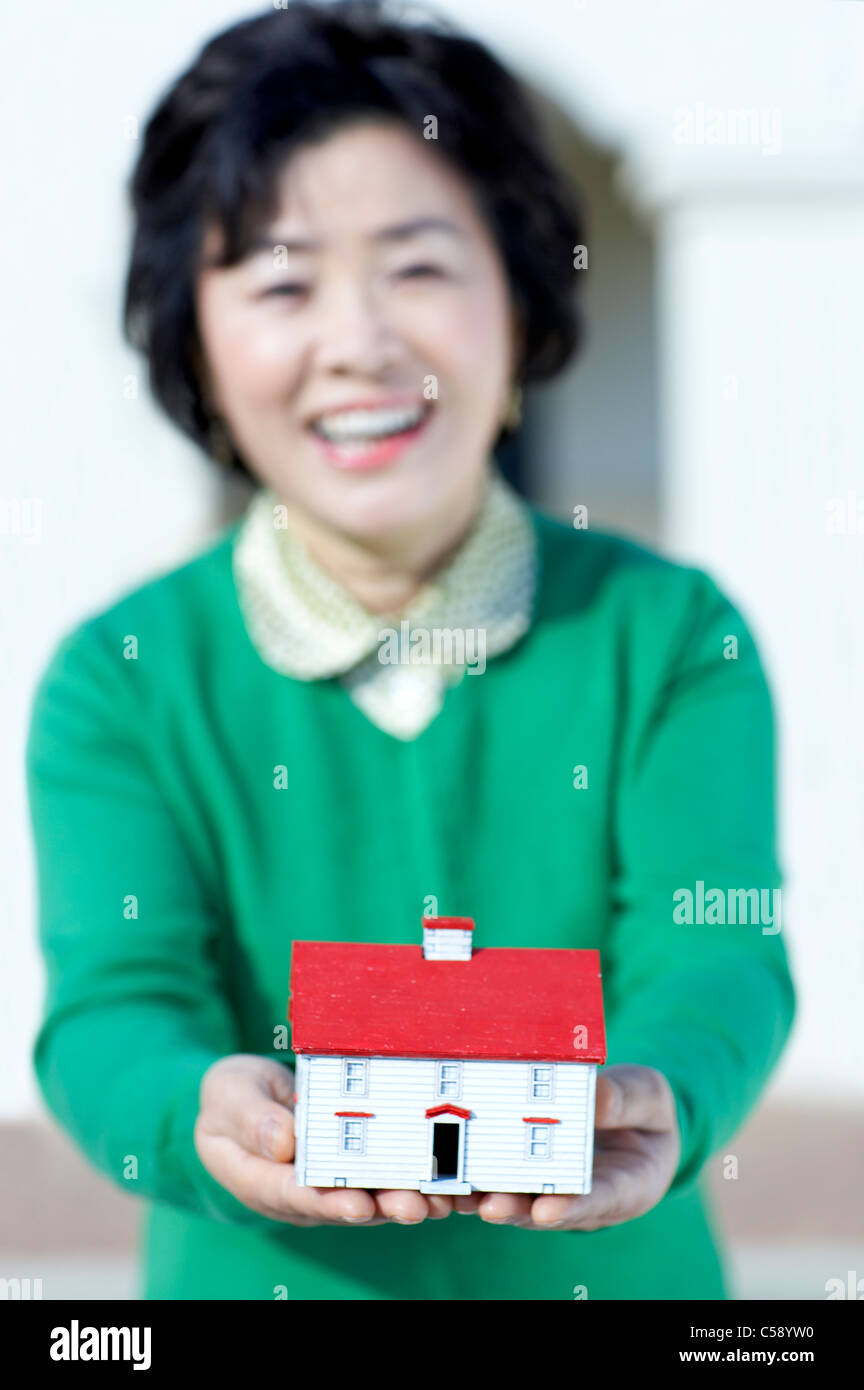 Portrait of senior woman holding model house Stock Photo - Alamy