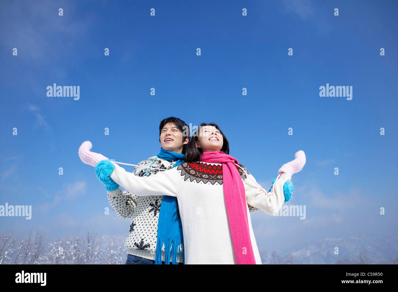 Young man and woman enjoying on snowcapped land Stock Photo - Alamy