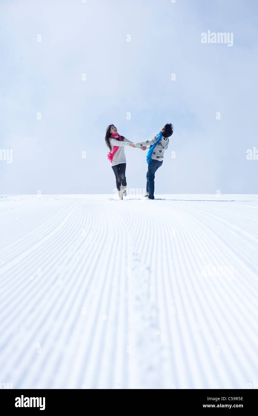 Young man and woman enjoying on snowcapped land Stock Photo - Alamy