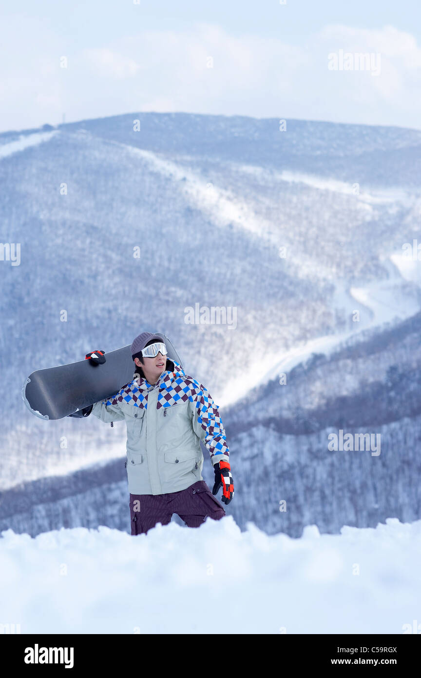Young man holding snowboard Stock Photo - Alamy