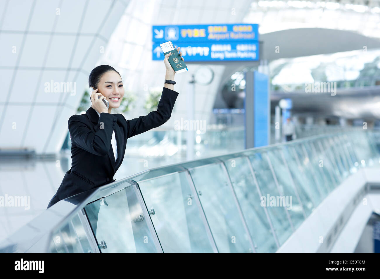 Close-up of businesswoman talking on mobile phoneholding passport and airline ticket Stock Photo