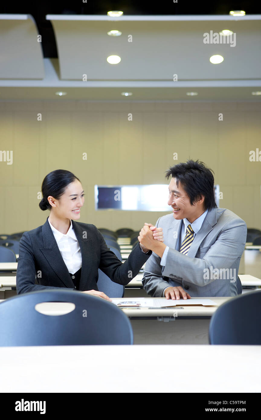Close-up of businessman and businesswoman holding hands Stock Photo