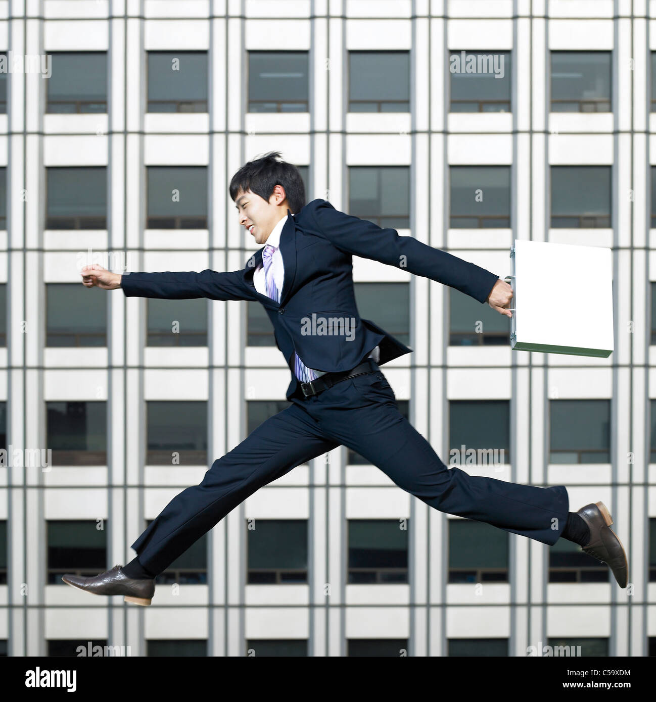 Side view of businessman jumping in air Stock Photo