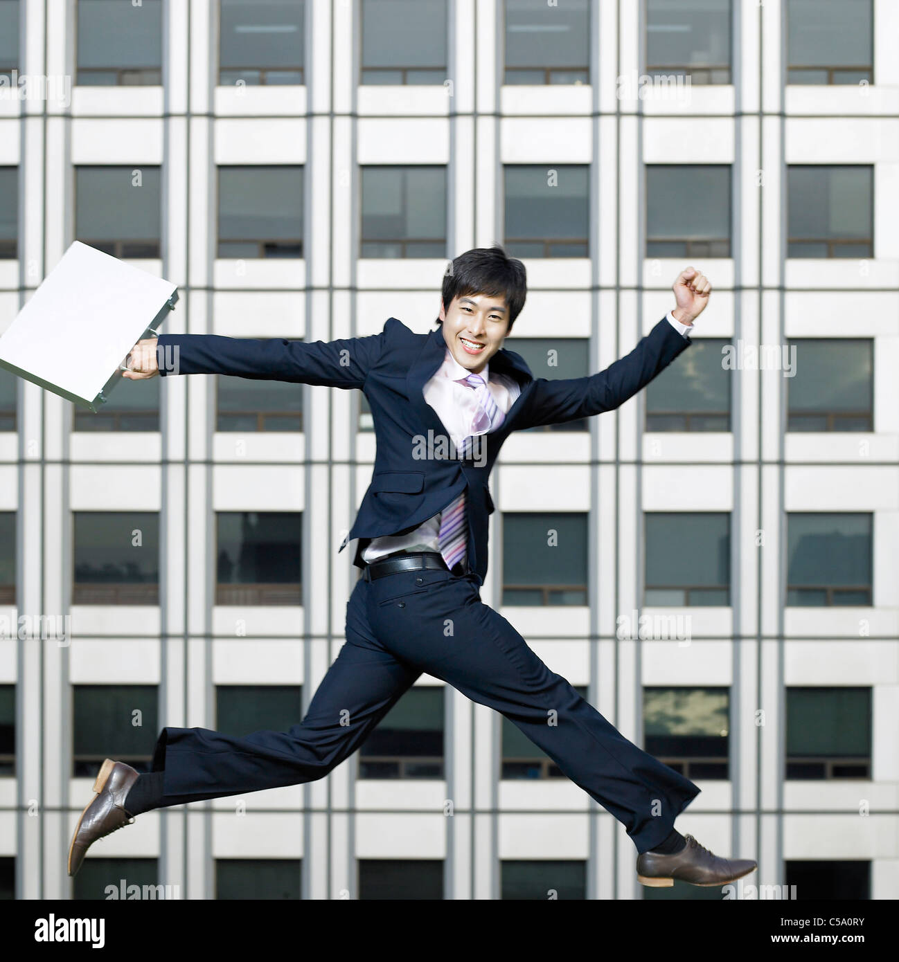 Side view of businessman jumping in air Stock Photo
