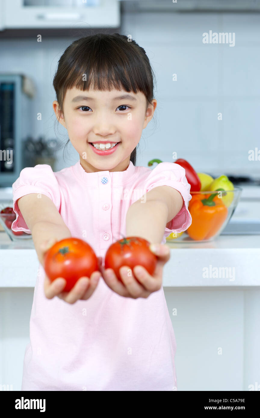 Portrait of girl holding tomatoes Stock Photo - Alamy