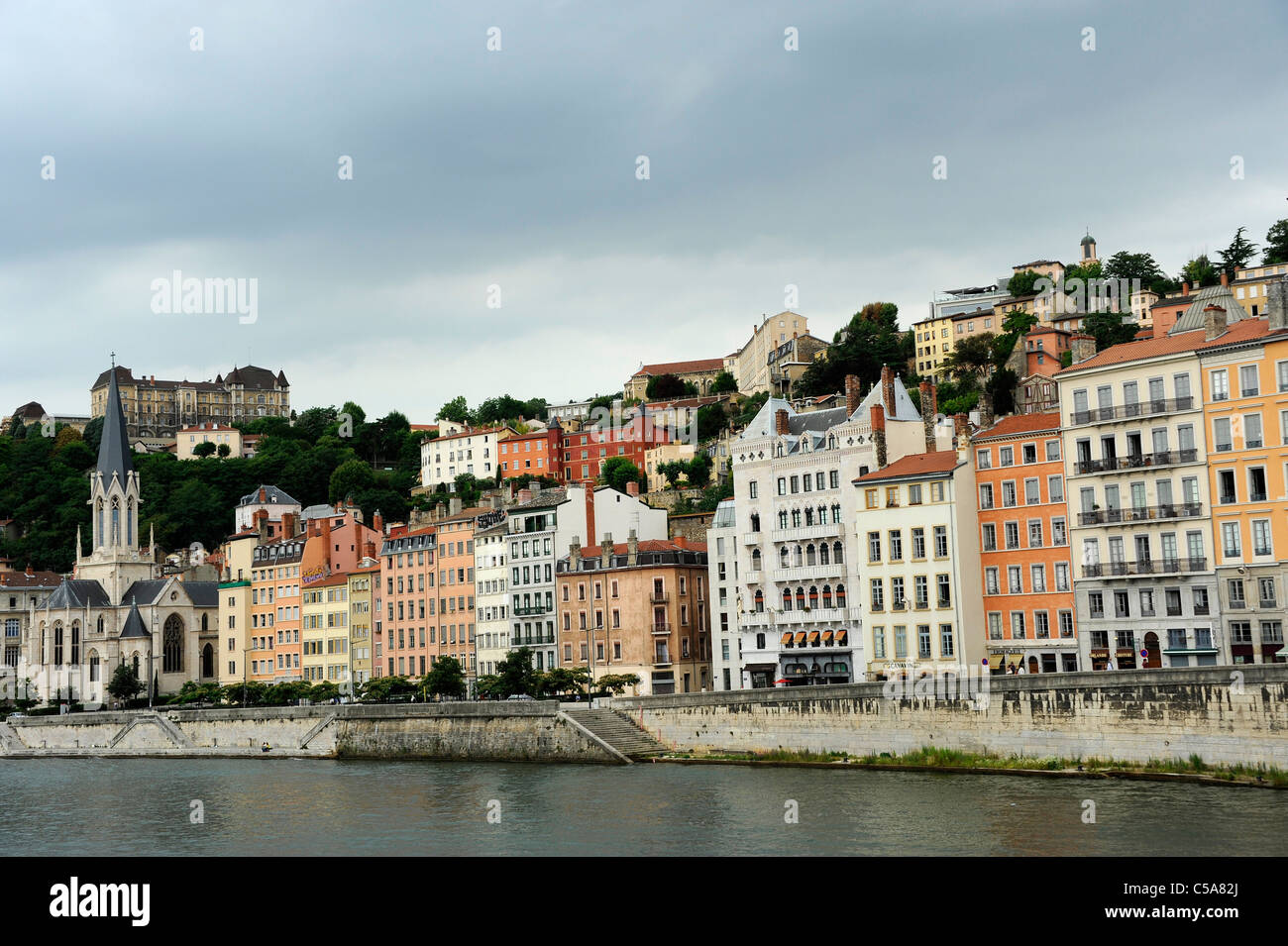 Buildings along the Saone River with a hilltop view of Basilica Notre Dame de Fourviere.  Lyon, France. Stock Photo