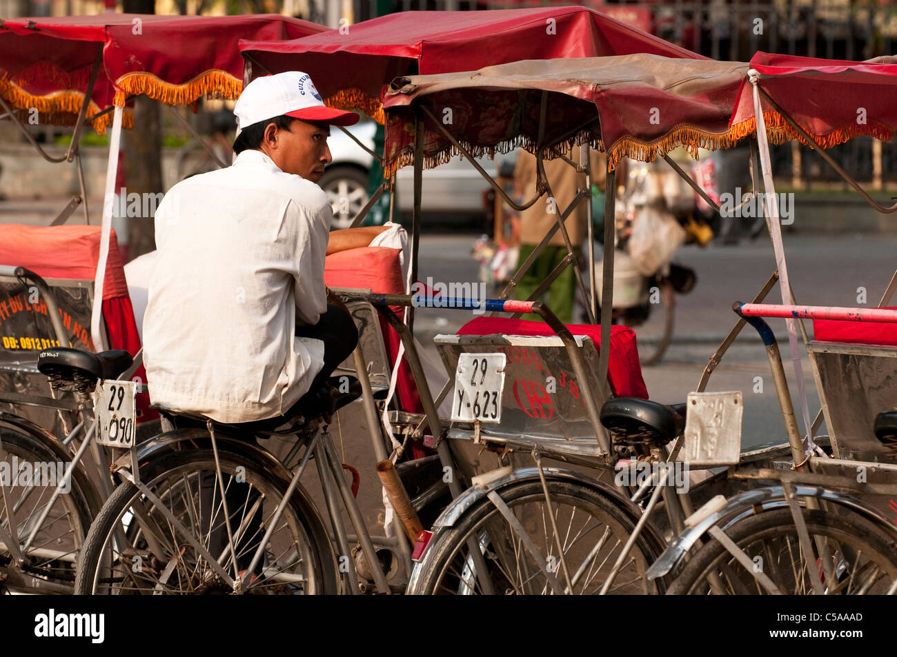 Rickshaw rider sitting on his cyclo at the Hanoi Opera House, Hanoi Old ...