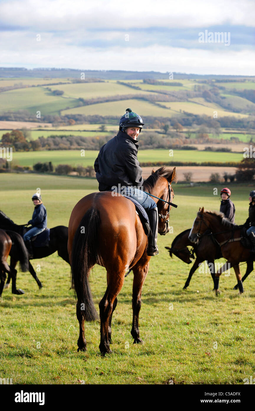 Work riders exercising racehorses at a stable in Gloucestershire UK ...
