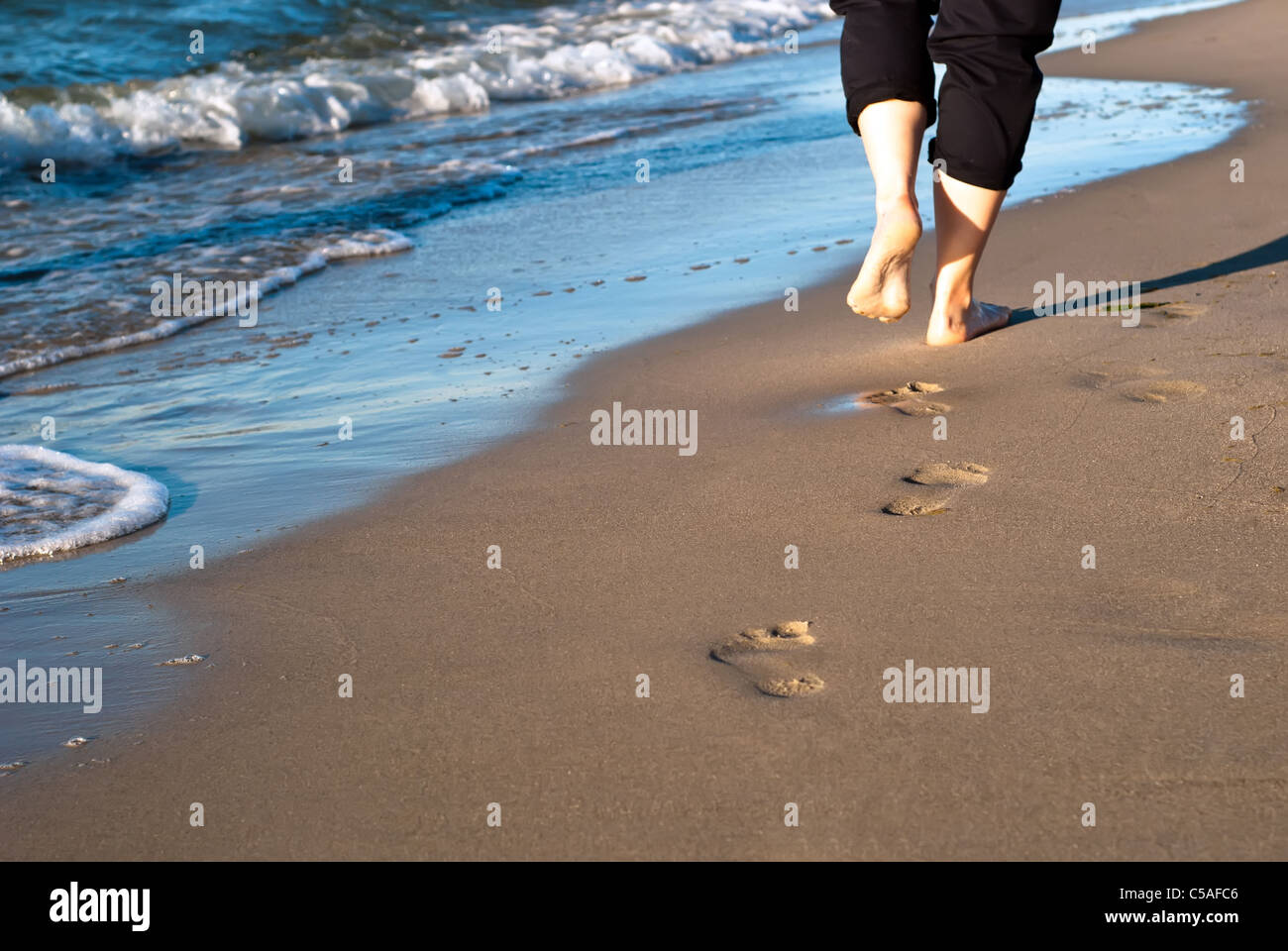 Footpure in the sand lead along the water Stock Photo Alamy