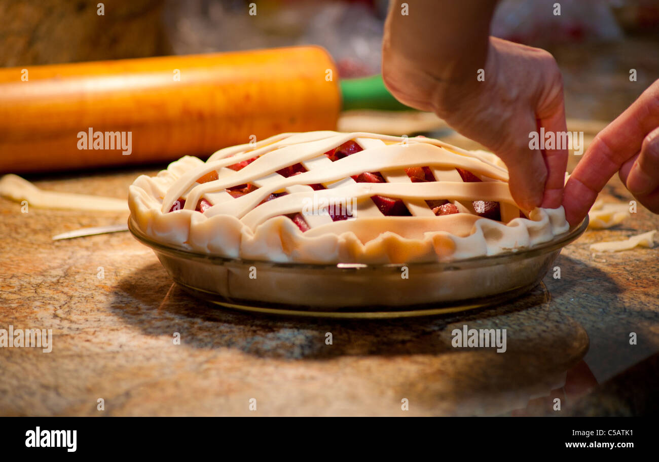 Woman prepping the Rhubarb pie crust for the oven. Stock Photo