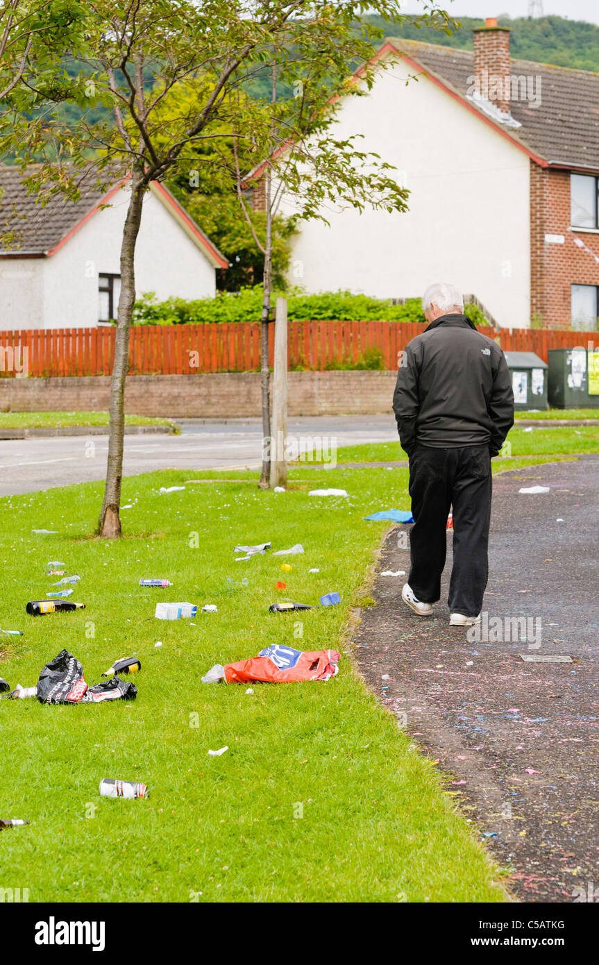 Man walks past litter after an outdoor drinking party Stock Photo