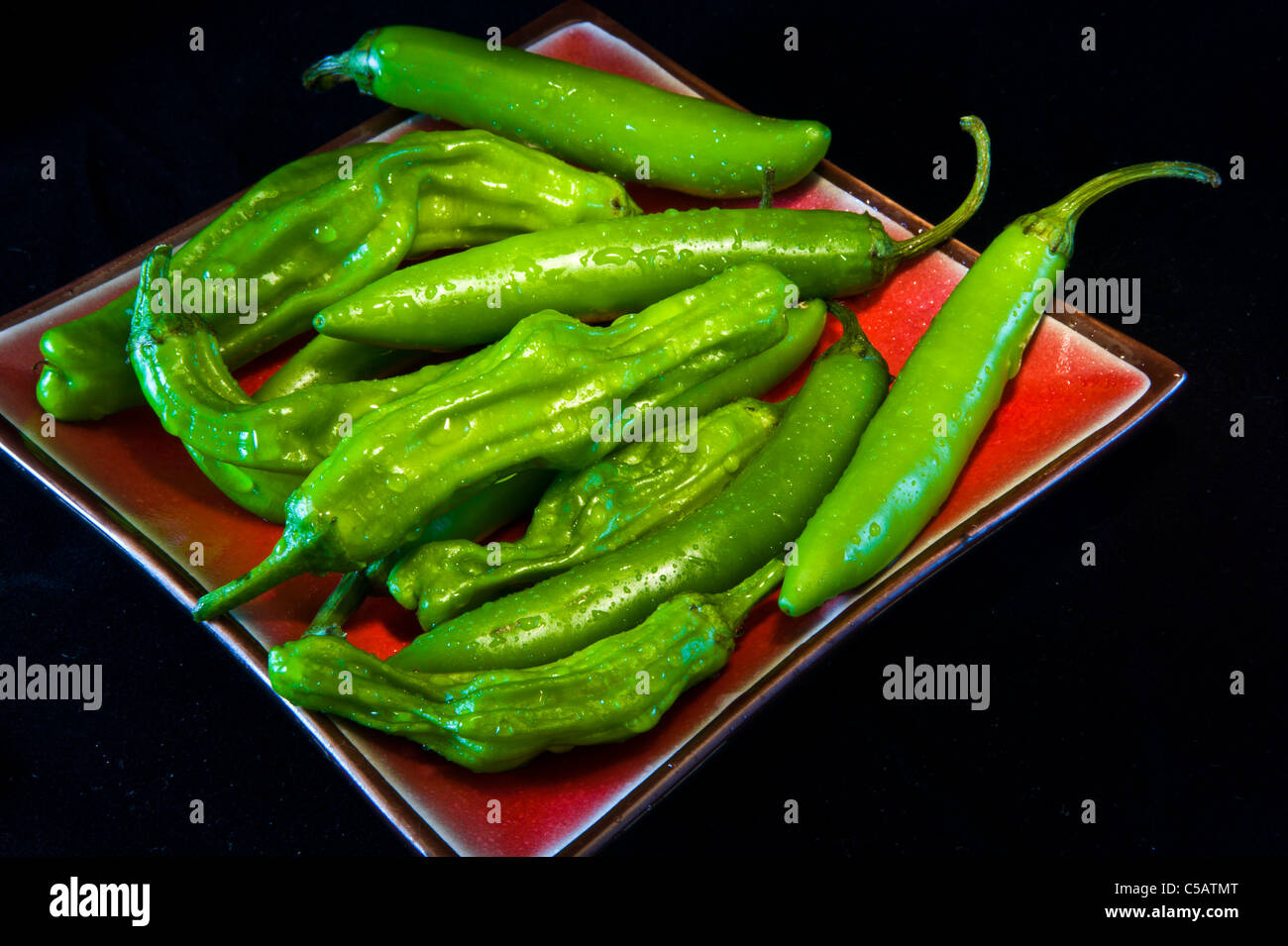A plate of Serrano and Japanese Shishito Peppers. Stock Photo