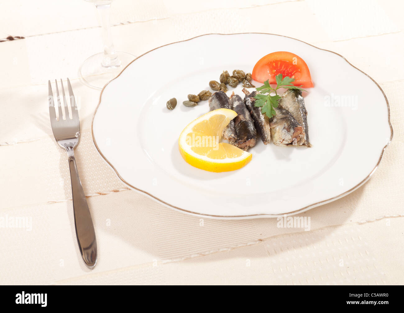 sardines in oil on a plate with lemon and capers Stock Photo Alamy