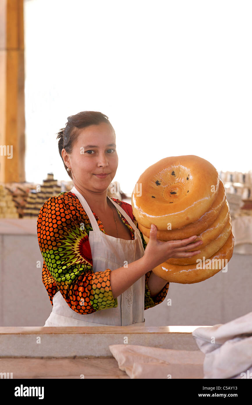 Uzbeki bread seller with Uzbeki style bread as cooked in a tandoor oven ...