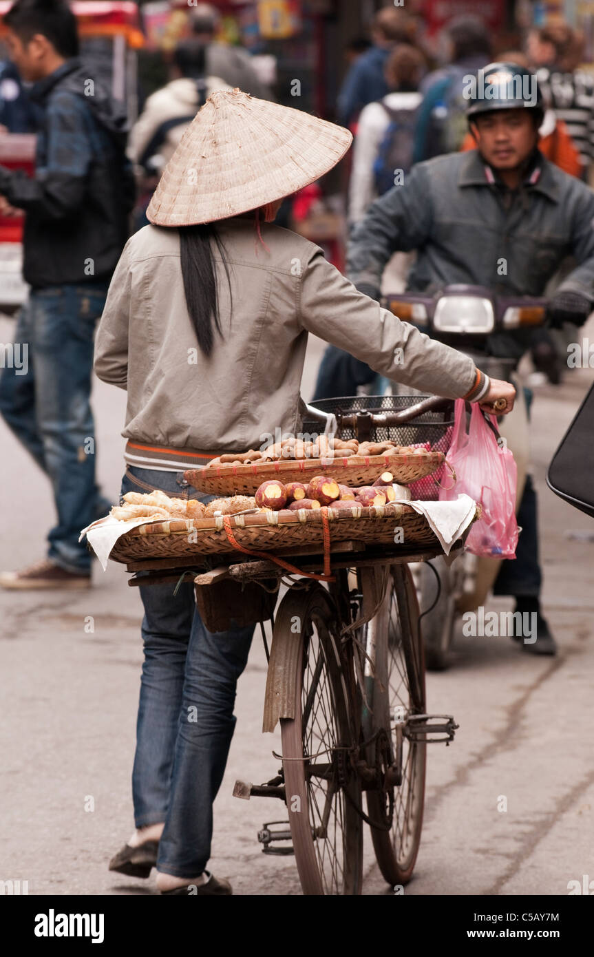 Street hawker with tamarinds and yams on her bicycle, Luong Ngoc Quyen St, Hanoi Old Quarter, Vietnam Stock Photo