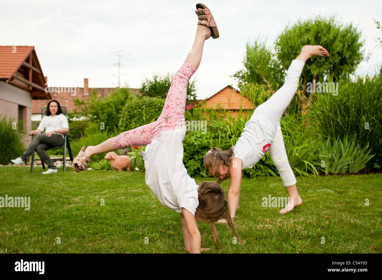 Children doing cartwheels in backyard Stock Photo