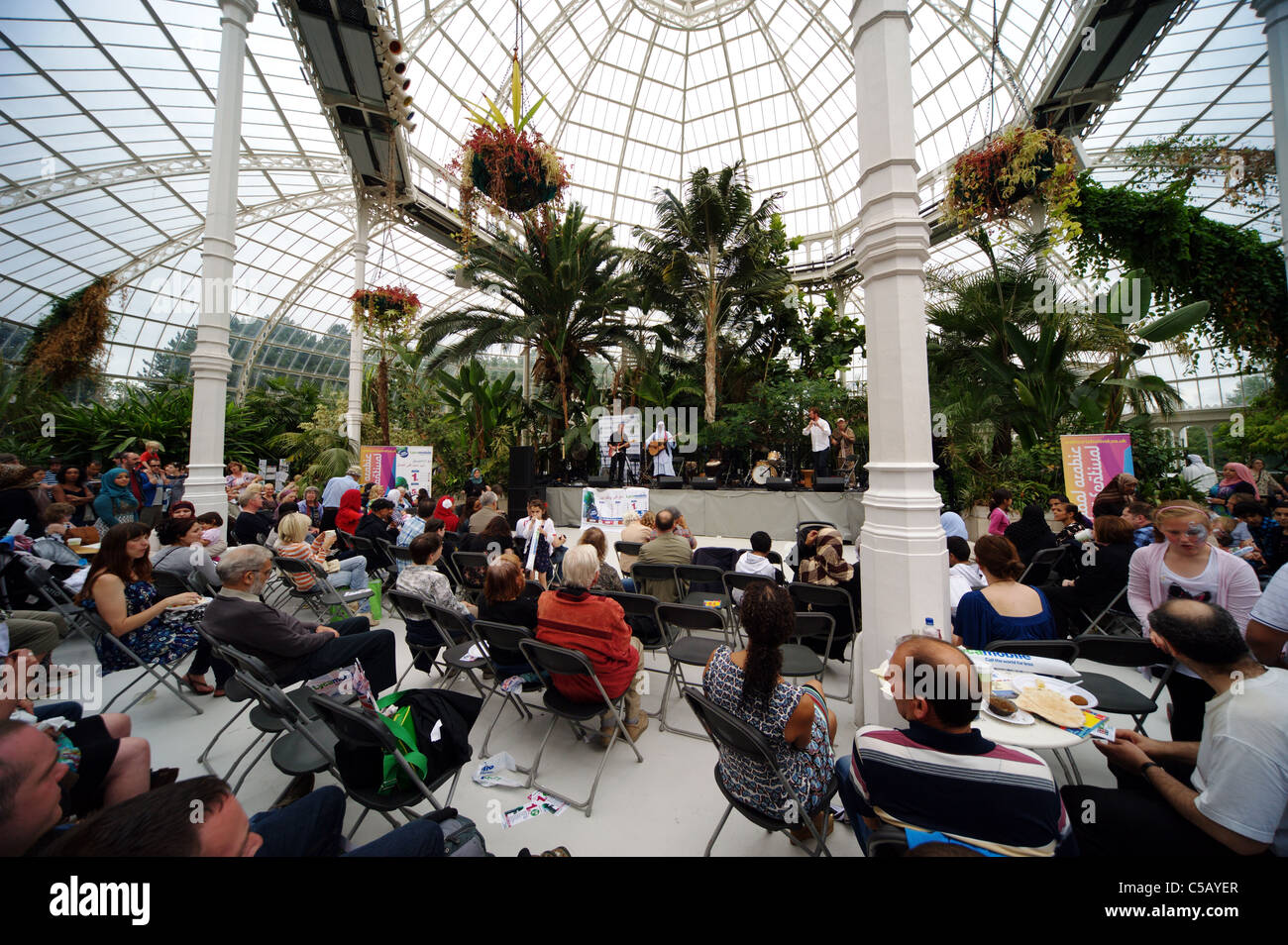Crowd and sign ; at Liverpool Arabic Arts Festival, Palm House Sefton